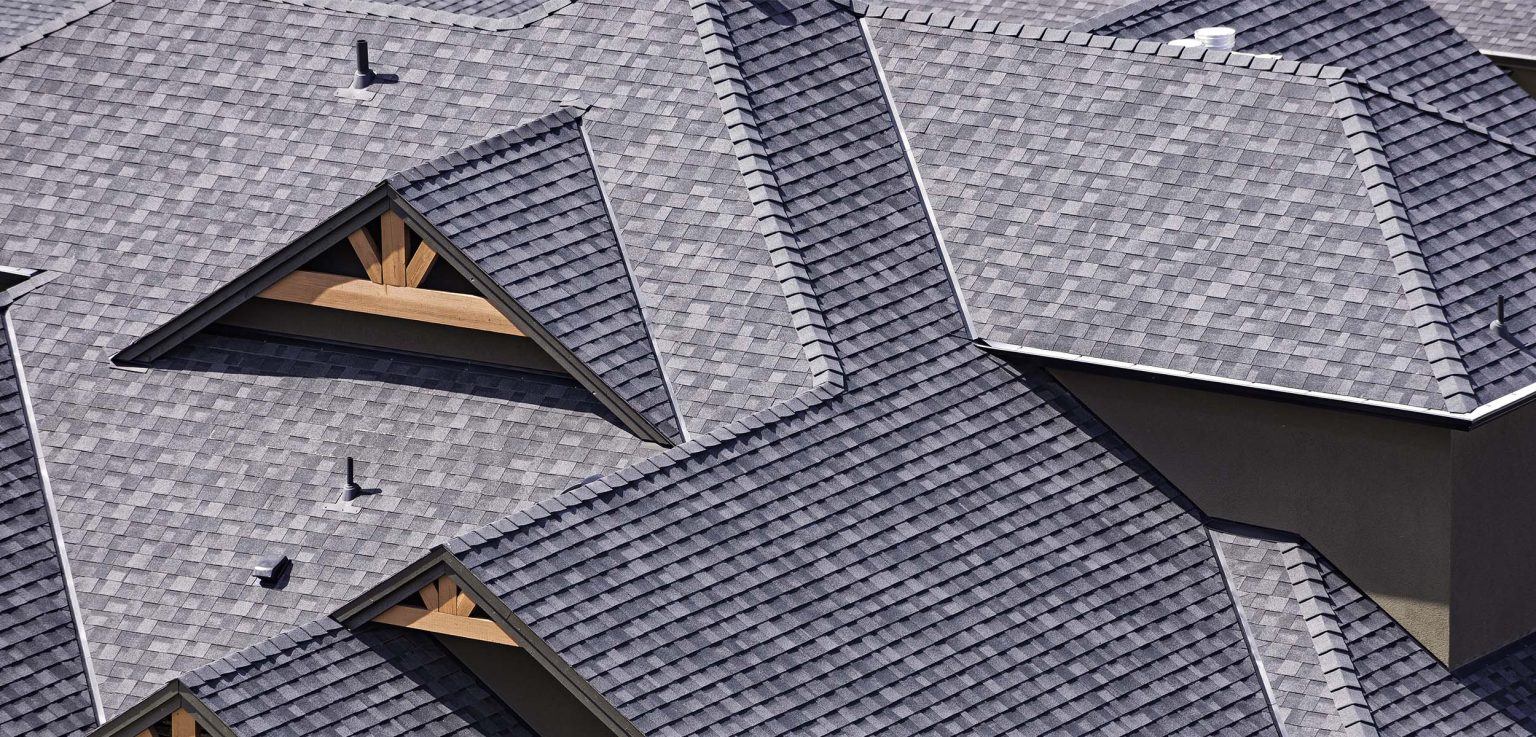 An aerial view of a grey shingled roof, showcasing exquisite craftsmanship by Paragon Roofing BC.
