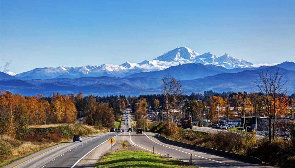 A road in Abbotsford with trees and mountains in the background. best roofers in abbotsford paragon roofing bc